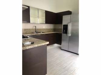 Large covered terrace leading to fenced backyard with landscaping in PH Nativa Panama