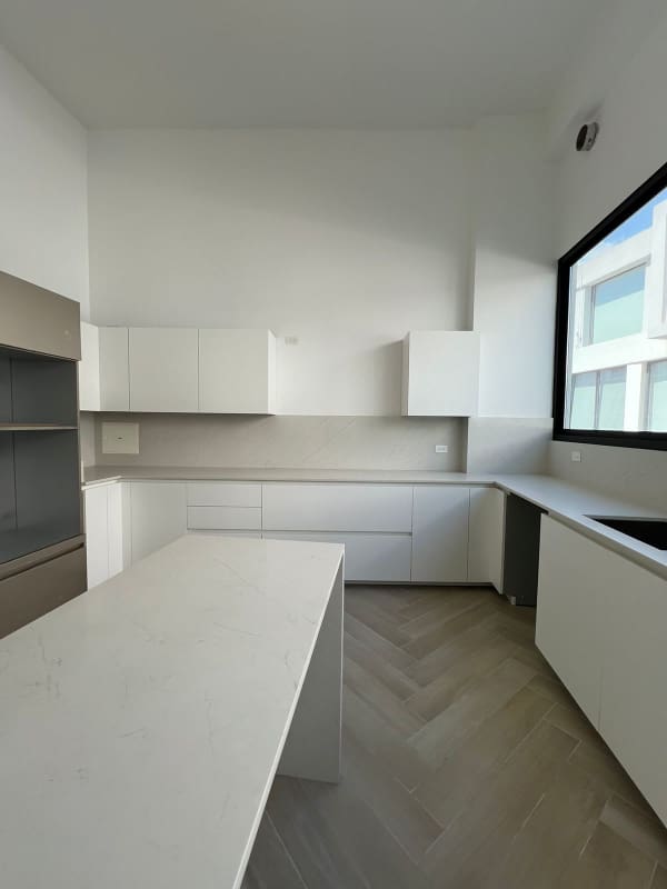 Modern gourmet kitchen with island, white cabinets, large windows at Ocean Reef Islands villa