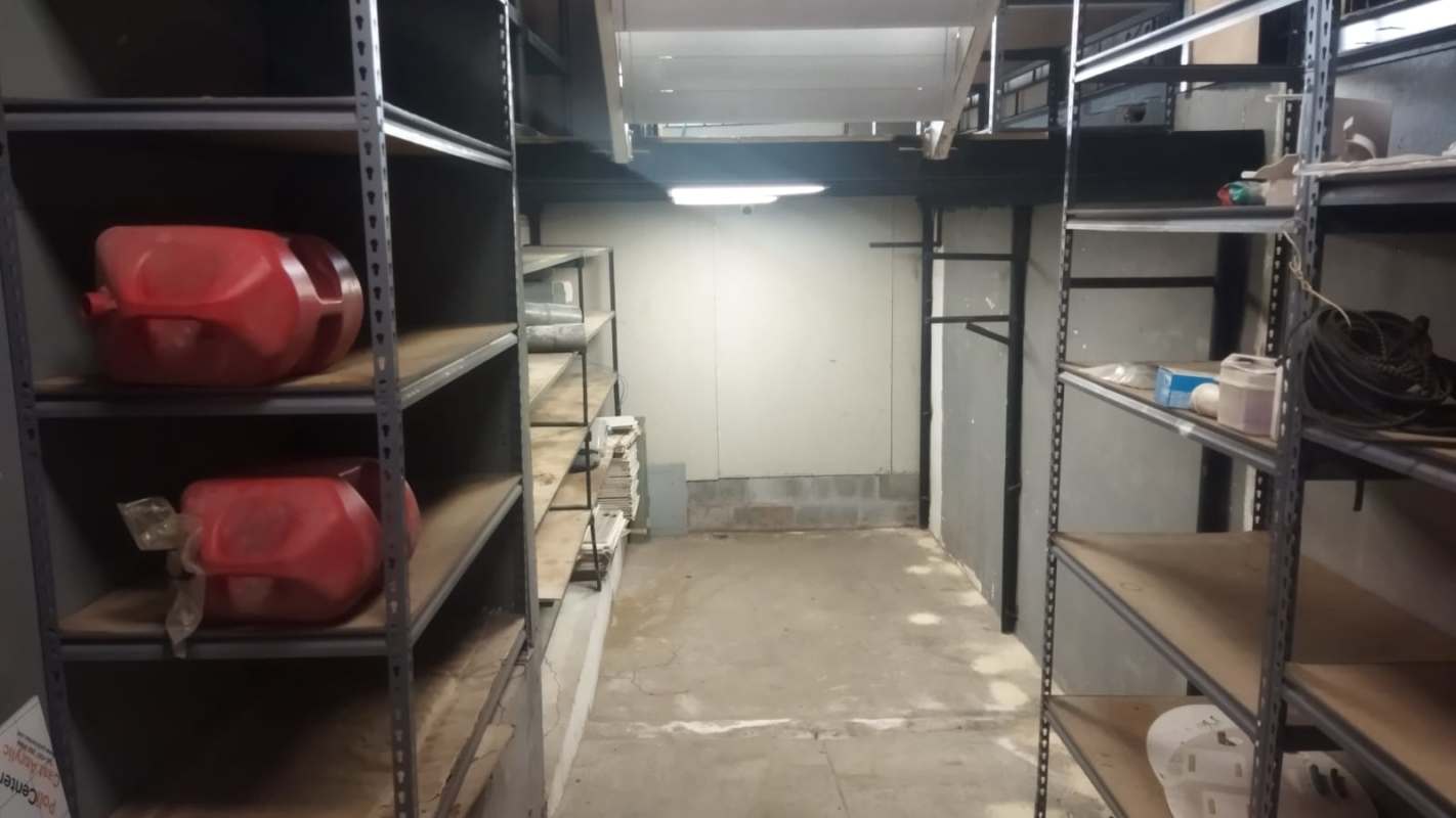 Industrial storage room with metal shelving concrete flooring fluorescent lights commercial house Panama