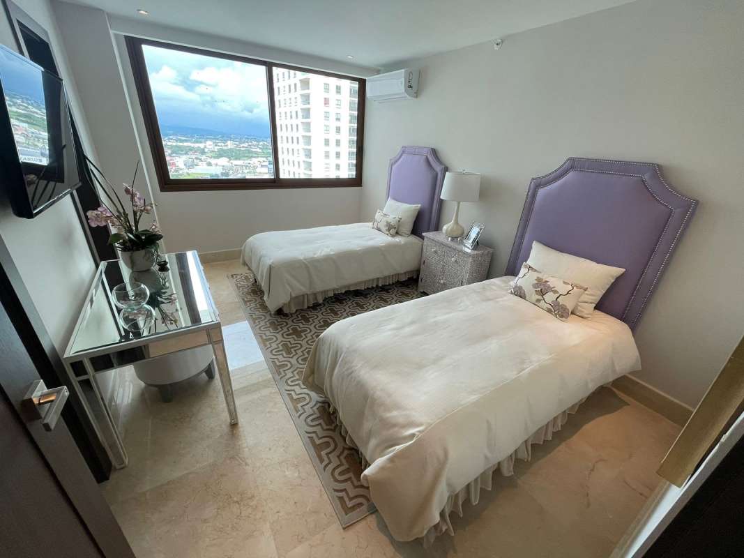 Guest bedroom with city views, twin beds, light colors in PH Ocean House Santa Maria Panama