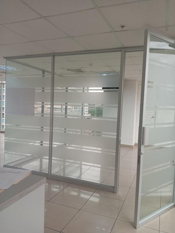 Interior office with glass partitions, ceramic tile floor and natural light in Bella Vista Panama