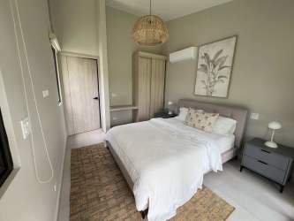Modern bedroom featuring vaulted ceiling, garden access sliding doors in Terra Viva Coronado