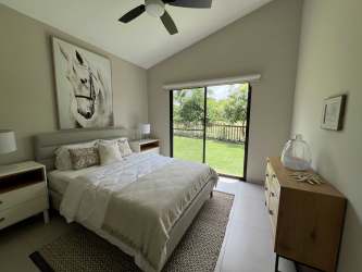 Bedroom with large sliding glass door and garden views in Terra Viva Coronado home for sale