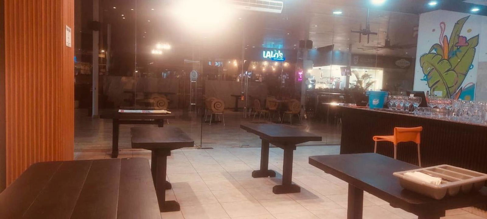 Casual dining area with mural artwork, bar counter, colorful interior at PH BICSA Panama City for lease