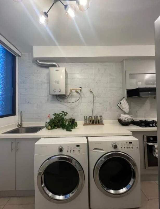 Laundry room area with washer dryer, cabinets and appliances in PH San Francisco Bay Panama