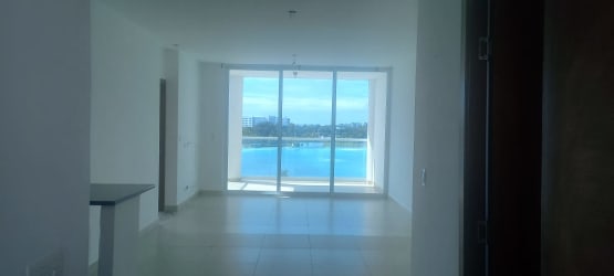 Spacious living area with large windows overlooking lagoon and ocean in Playa Blanca Panama condo