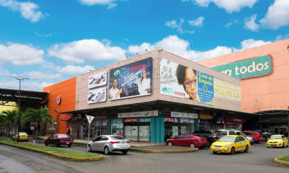 Corner facade of Plaza Cuatro Altos retail center with billboards, parking, and multiple commercial units in Colón, Panama