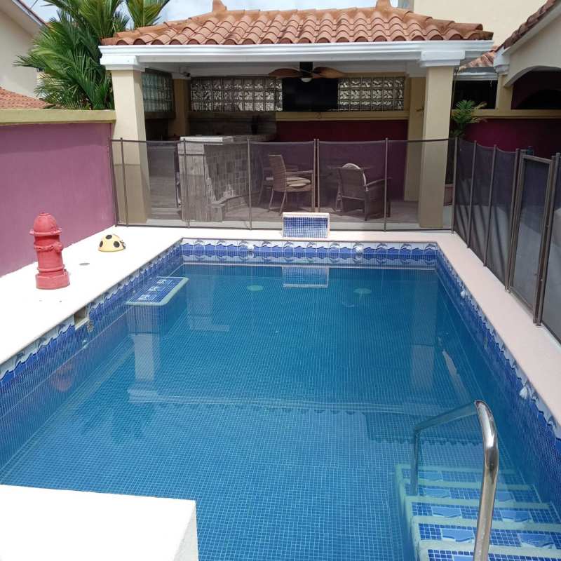 Spacious living and dining area with modern furniture and ceiling fans in Brisas del Golf