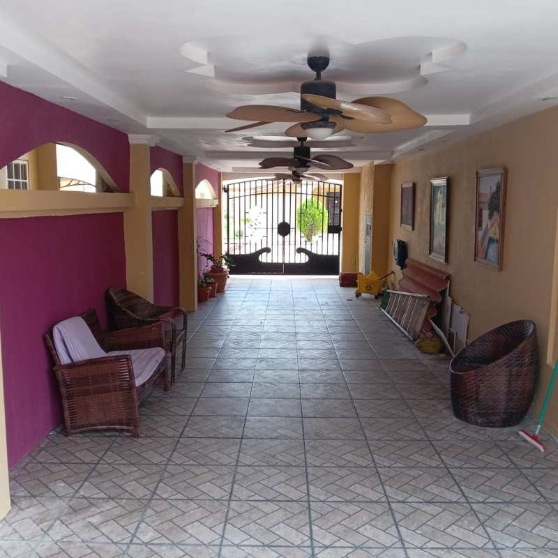 Tiled covered garage area with seating, ceiling fans, security gate Brisas del Golf Panama