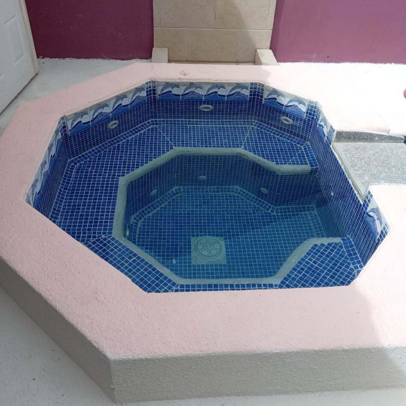 Private jacuzzi with blue tiles and pool in backyard Brisas del Golf Panama City