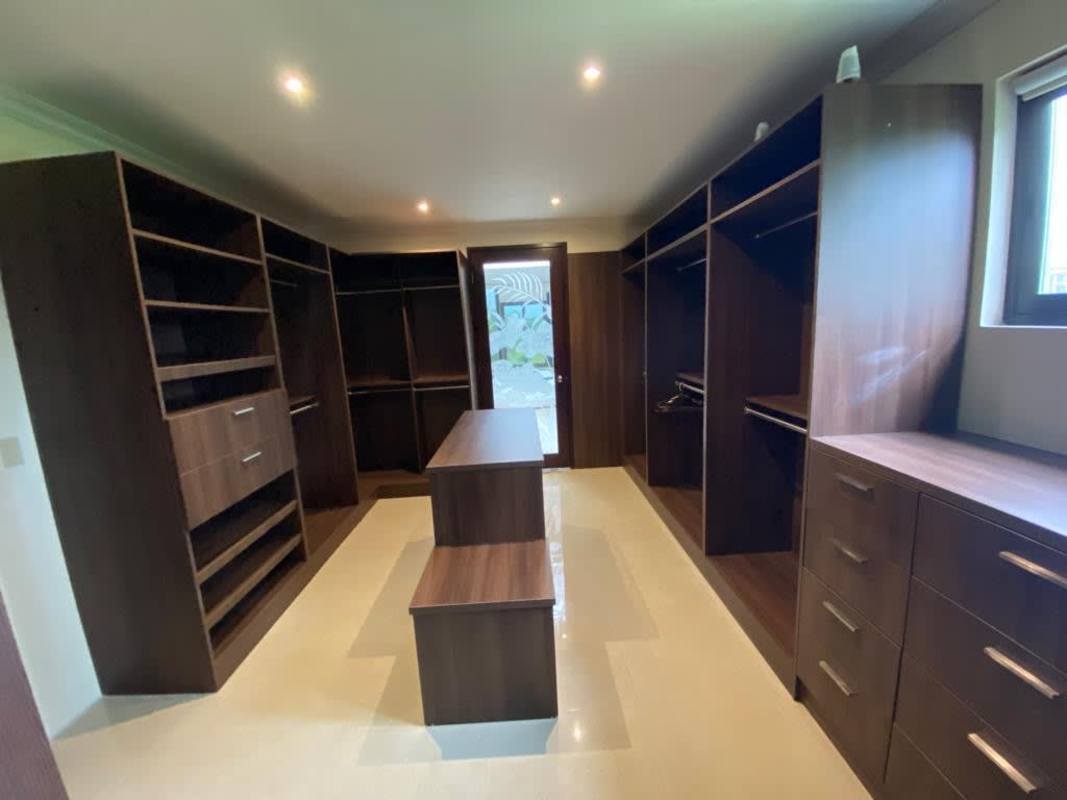 Spacious modern walk-in closet with island cabinetry in Santa Maria mansion Panama