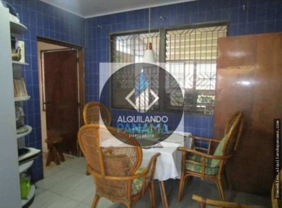 Traditional dining or reception area with blue tile walls security window bars wicker chairs San Francisco Panama