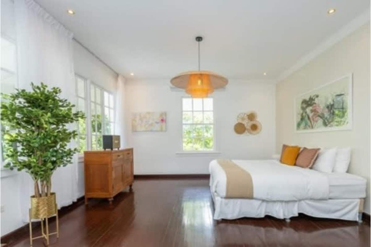 Bright bedroom with hardwood floors, large window, garden view in Cerro Ancon colonial home Panama