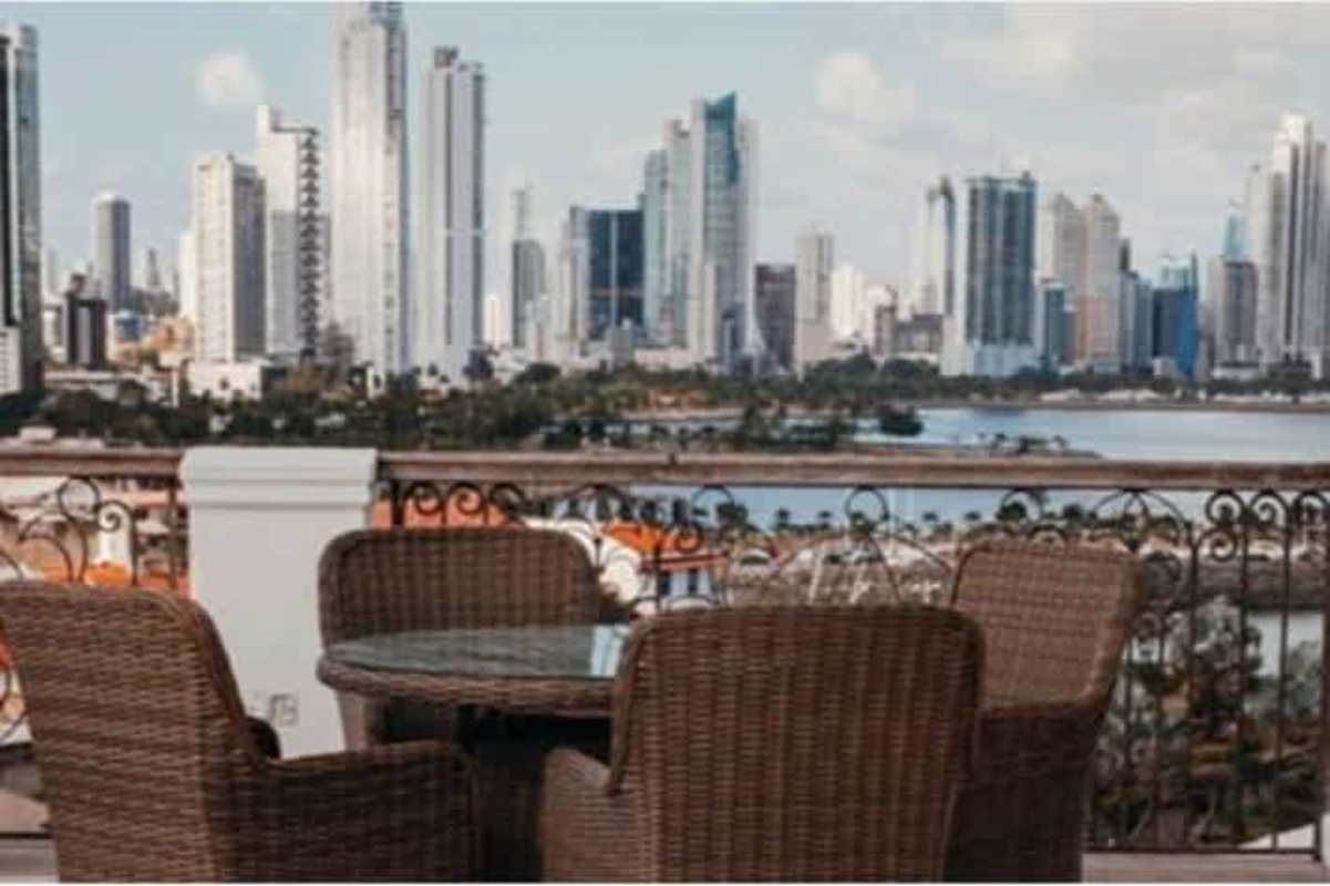 Balcony with table chair city skyline waterfront view historic Casco Viejo Las Clementinas Panama