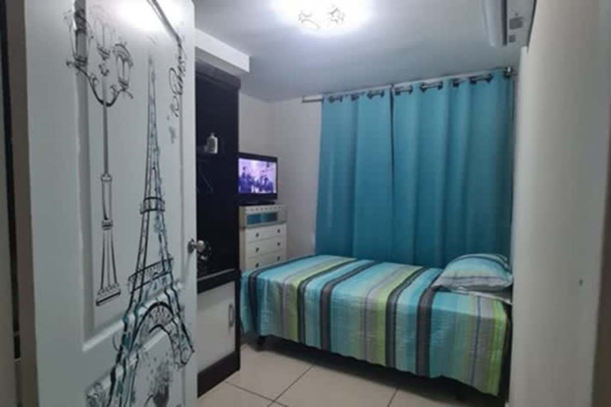 Minimalist bedroom with air conditioning, blue curtains and tile floors in PH Vía España Panama City