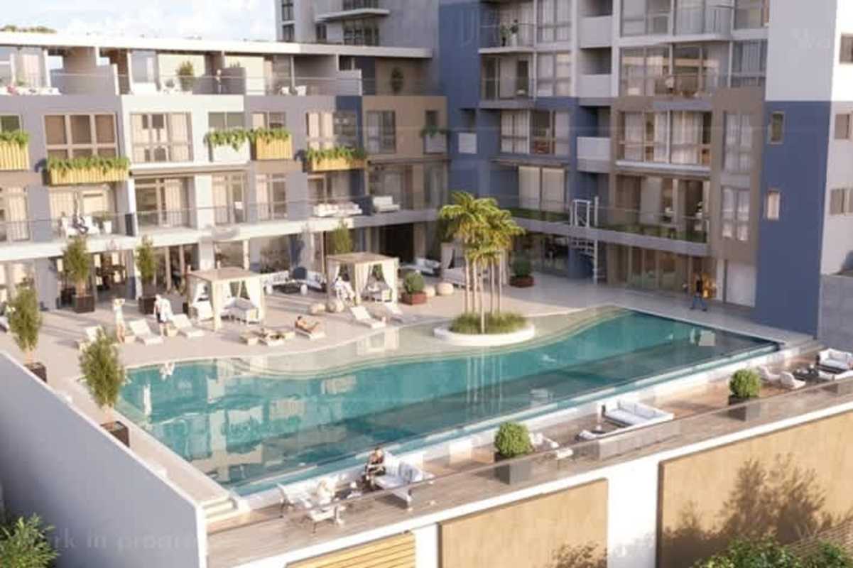 Resort-style pool area with cabanas and palm trees at Oceana Residences Santa María