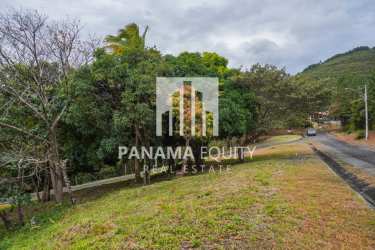 Hilly vacant land near paved road surrounded by trees Granada Altos del María Panama