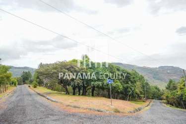 Vacant lot on quiet paved street surrounded by greenery and mountains Granada Altos del María Panama