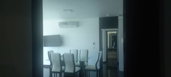 Modern dining area with glass table wall-mounted TV air conditioning Founders Tower Panama