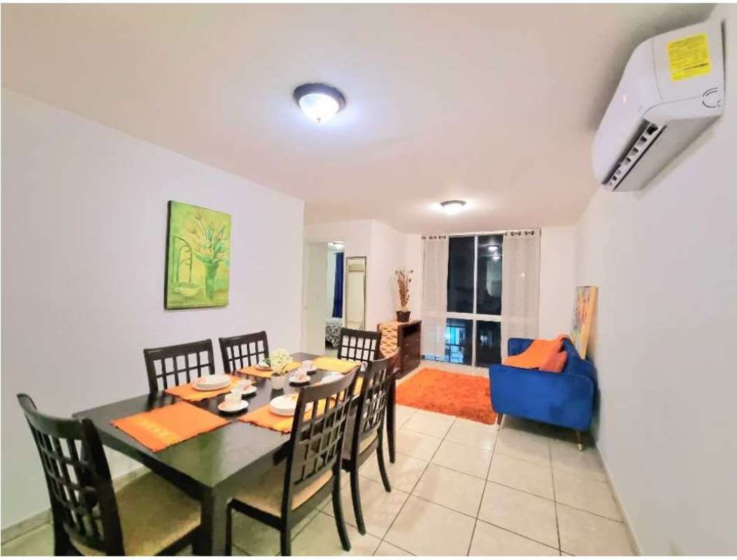 Cozy living room with blue couch, orange accents, AC, and decor PH Sunshine Carrasquilla Panama