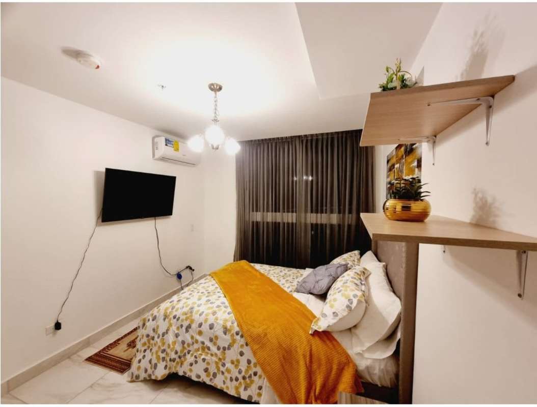 Modern open space with blue sofa, marble floors, and dining area in oceanfront apartment PH BICSA