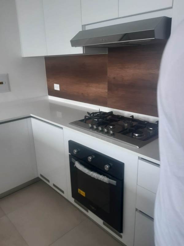 Open kitchen concept with wood backsplash white cabinetry PH Van Gogh Panama