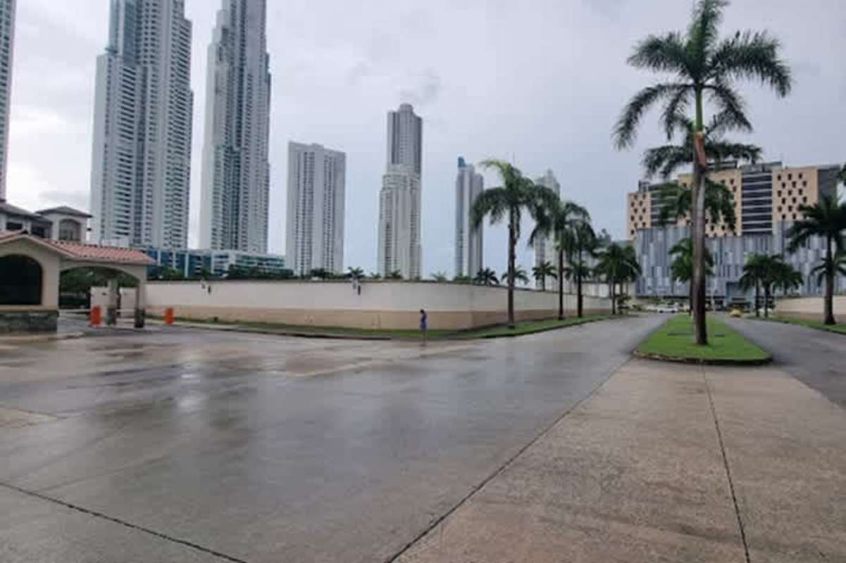 Spacious living room with double-height ceiling, navy chairs, sectional sofa, modern art in Casa Bianca Panama