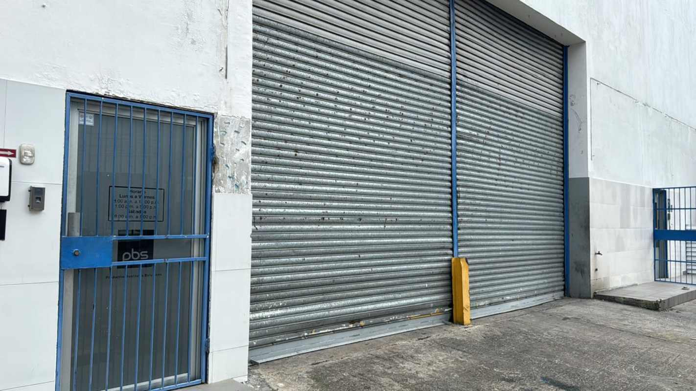 Exterior of industrial warehouse with roll-up metal door and parking Costa del Este Panama