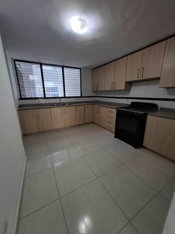Contemporary kitchen with cabinets, window and tile backsplash in Bella Vista apartment Panama