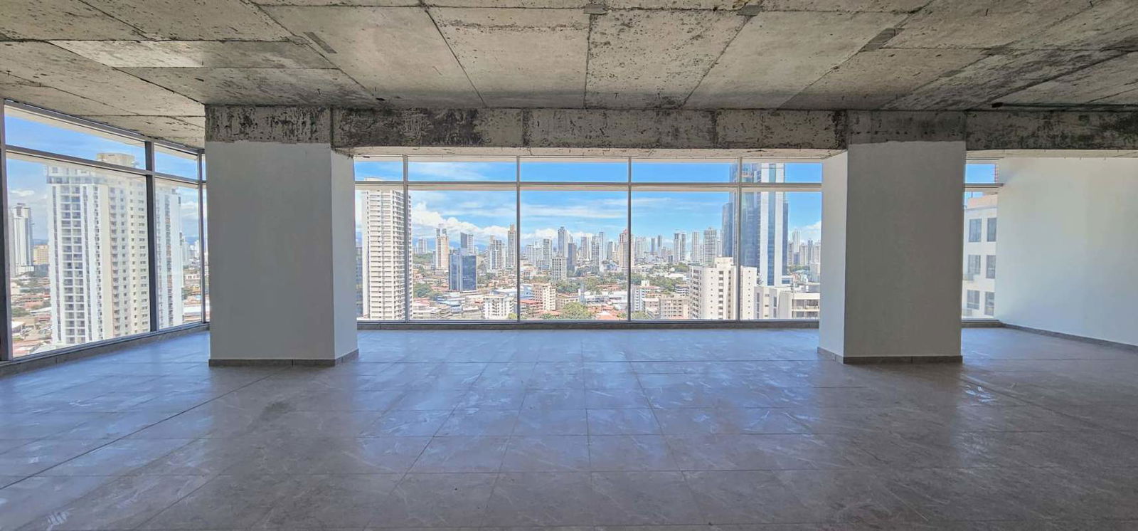 Minimalist bathroom with white sink and toilet, gray tile floor inside premium office in Obarrio