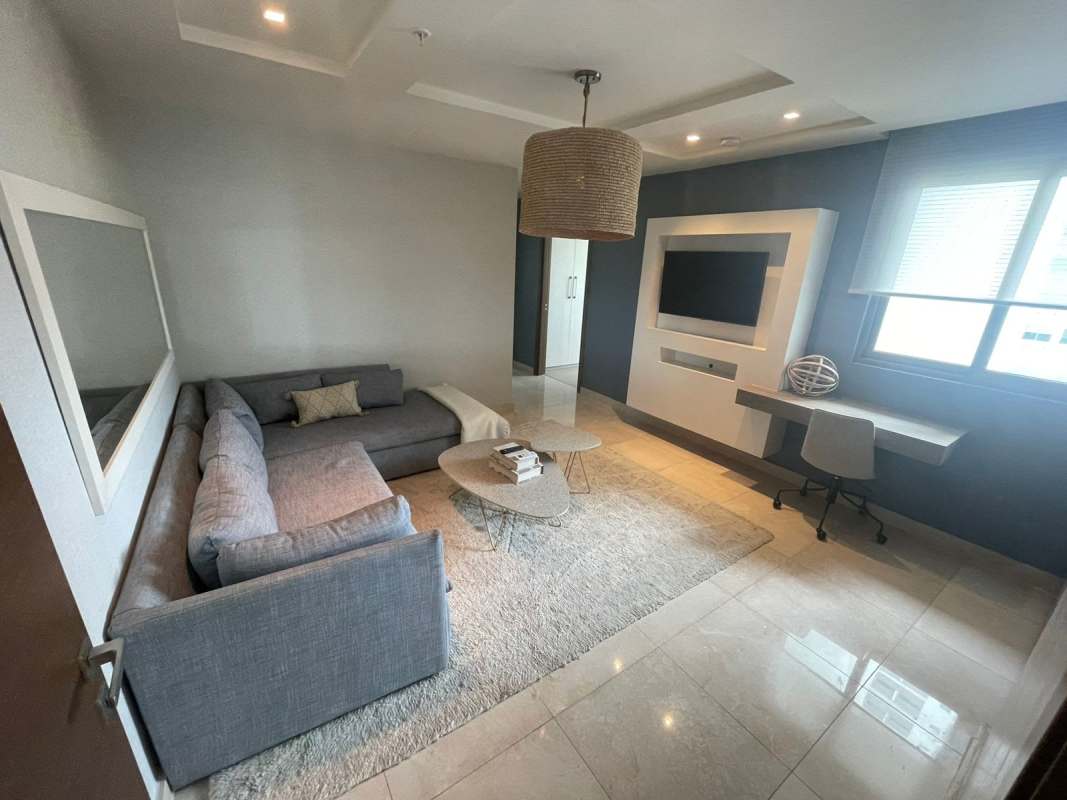 Bright open-concept living room with marble flooring and city skyline view in PH Park Lane