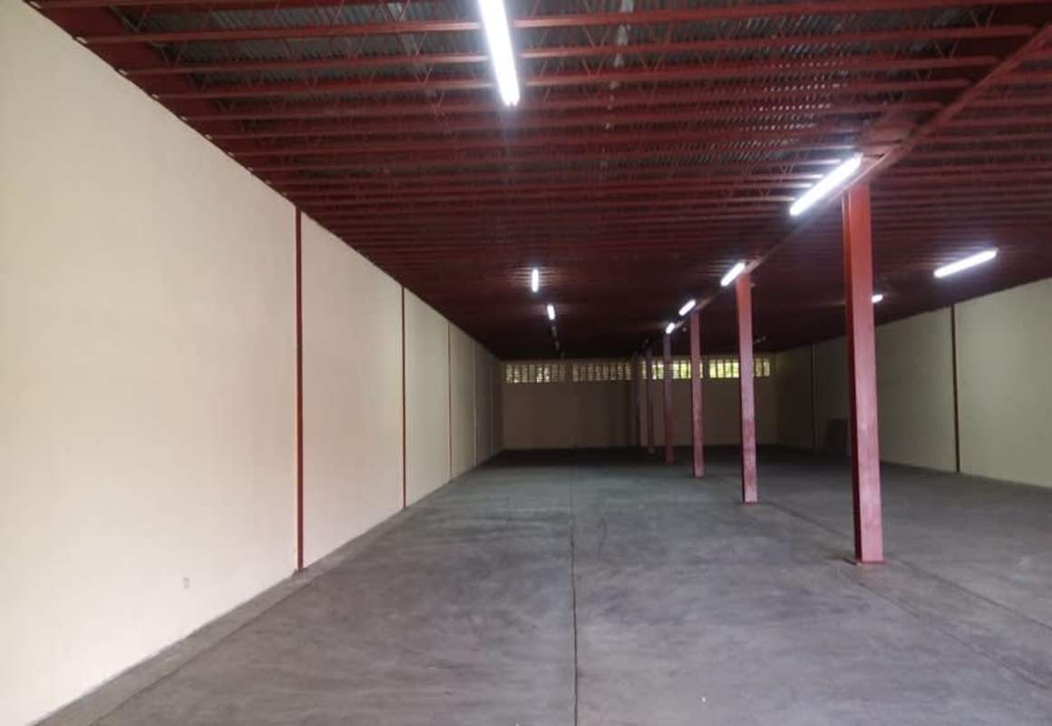 Empty commercial warehouse with concrete flooring, steel beams, and mezzanine level in Juan Díaz Panama City