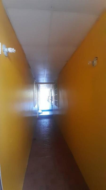 Single-story yellow house with decorative fence gated entrance and parked vehicle in Ciudad Radial Panama