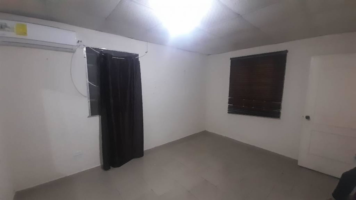 Unfurnished minimalist kitchen tiled floor basic cabinets window with bars Ciudad Radial Panama apartment