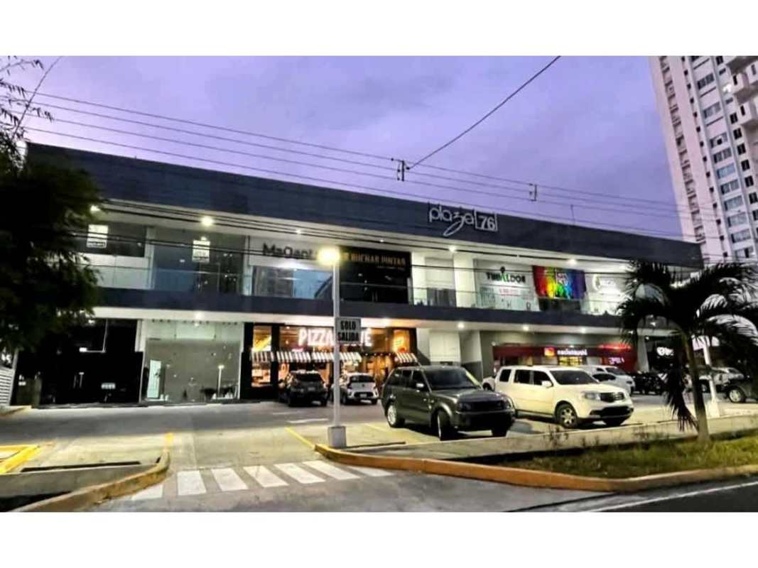 Modern two-story shopping center with storefronts and parked cars in Plaza 76 San Francisco Panama
