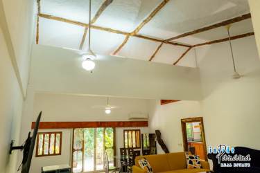 Spacious kitchen with wood cabinets, large island cooktop, windows overlooking tropical greenery Chapala Panama