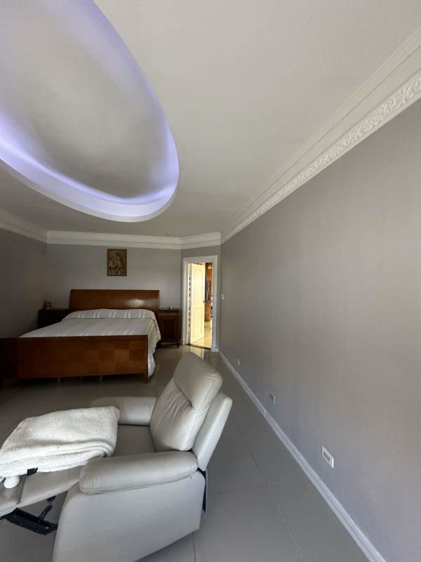 Spacious bedroom with tray ceiling, crown molding, tile floors in luxury estate Altos del Golf Panama