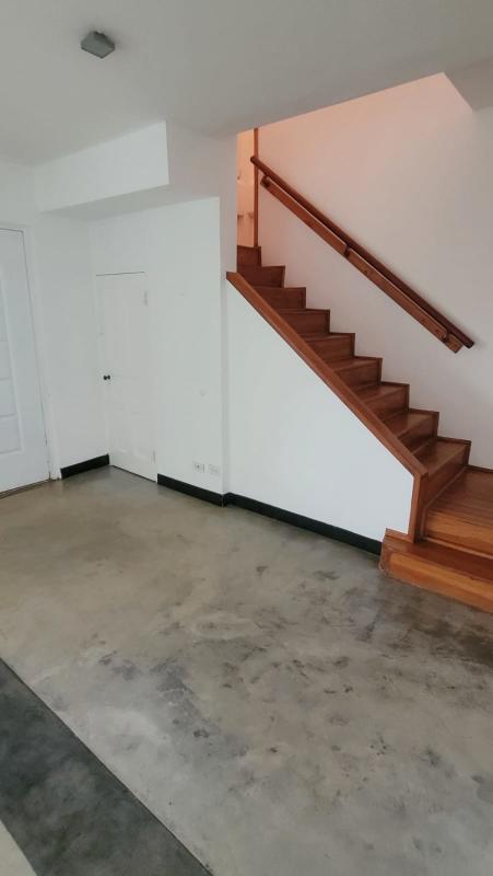 Minimalist hallway with wooden staircase in Albrook family home Panama