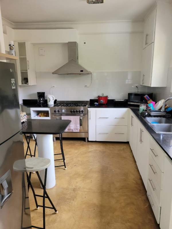 Modern kitchen with white cabinets, black countertops, island, stainless steel appliances Albrook Panama