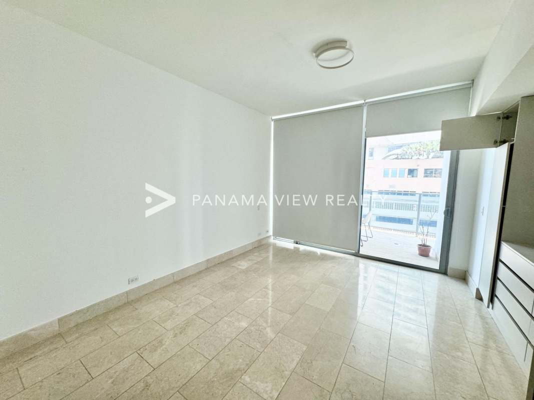 Large balcony with glass railing overlooking Pacific Ocean and city skyline at PH Grand Tower