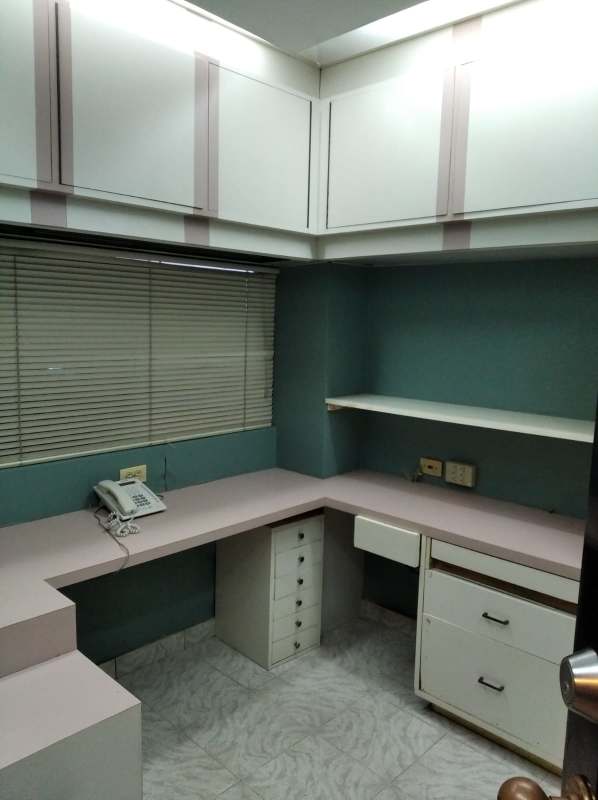 Private office corner with built-in cabinetry, corner desk and blinds in PH El Carmen Business Center