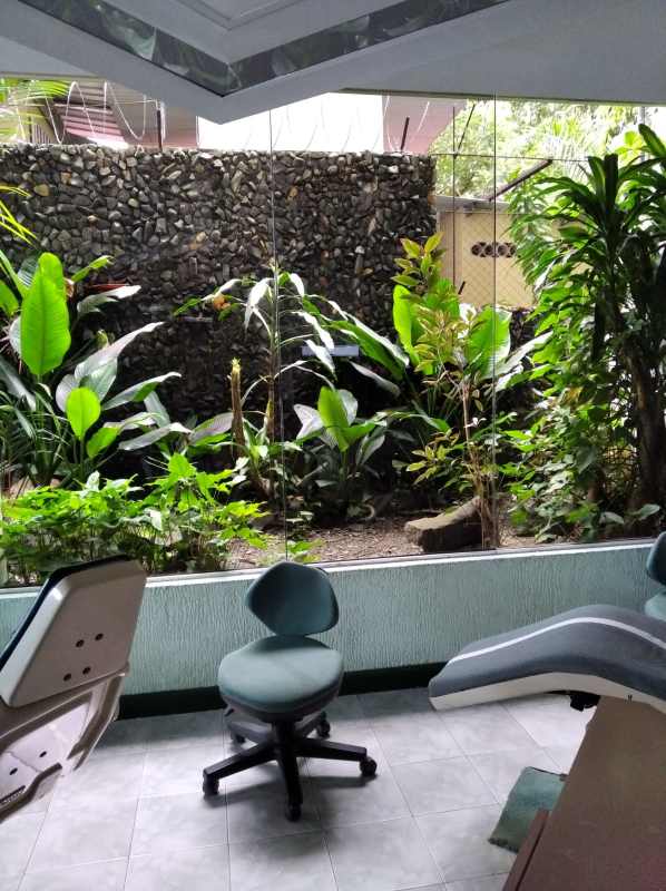 Clinic treatment room with large window facing garden stone wall in PH El Carmen Panama