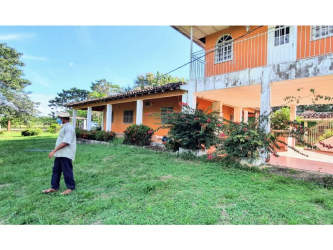 Two-story orange and white country house with lush garden in Tonosí Los Santos Panama