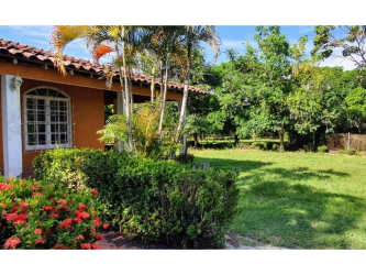 Country-style house with arched windows and tiled roof surrounded by gardens in Los Santos Panama