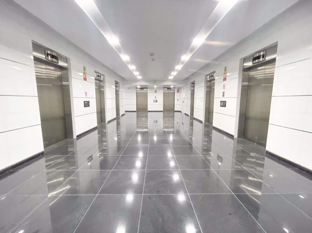 Exterior of modern high-rise towers with glass facade, landscaped grounds and flag poles at Oceania Business Plaza