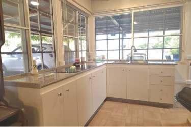 Corner kitchen with granite countertops and panoramic window in Gorgona beach home Panama