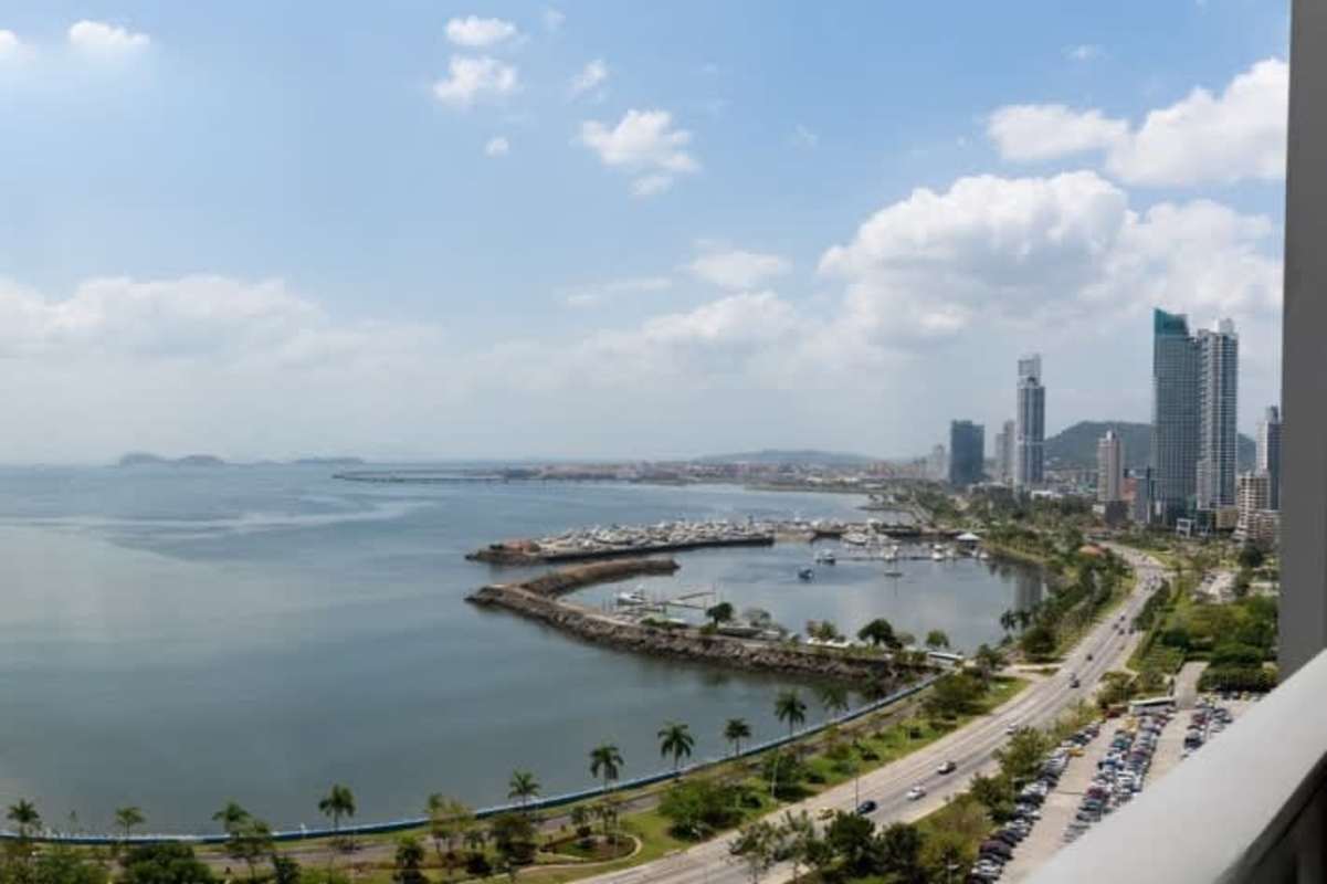 Modern kitchen with wood cabinetry and stainless appliances in Yoo Panama apartment