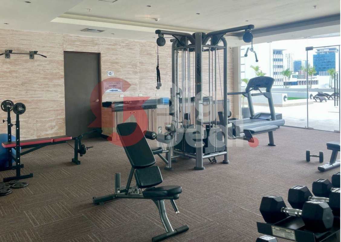 Resident fitness center with equipment and large windows at PH Denovo Obarrio Panama