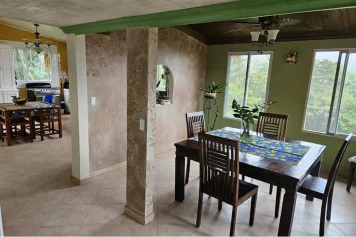 Traditional living room with rustic furniture, large windows, views to tropical jungle Cerro Azul Panama