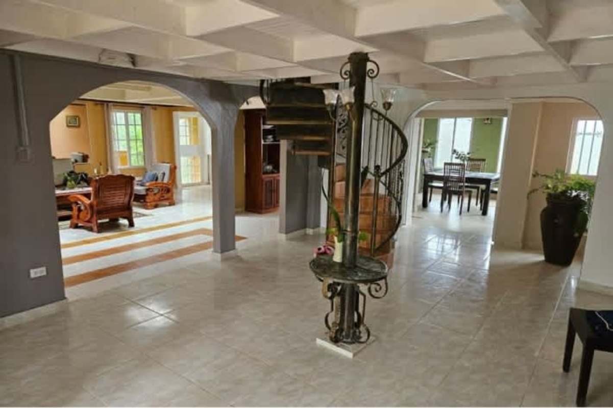 Rustic balcony with arches, stone columns, lush garden view at mountain home Cerro Azul Panama
